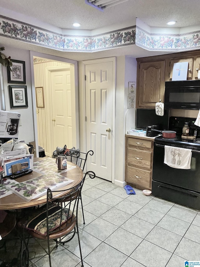 kitchen featuring light tile patterned floors, black appliances, and a textured ceiling