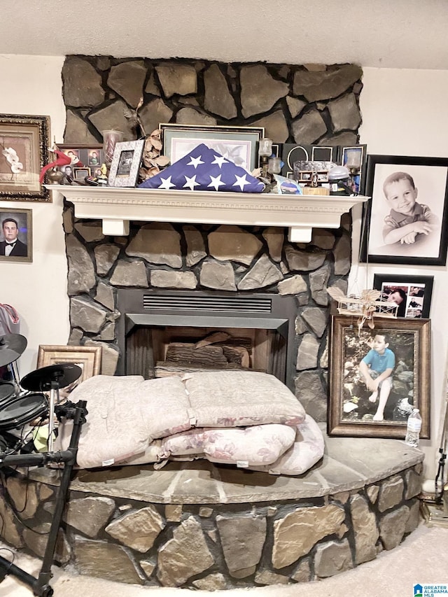 interior details with a stone fireplace and carpet