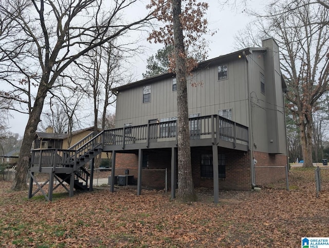 rear view of property with a wooden deck and cooling unit