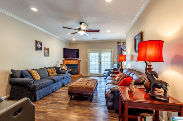 living room featuring ornamental molding, a textured ceiling, ceiling fan, and dark hardwood / wood-style flooring