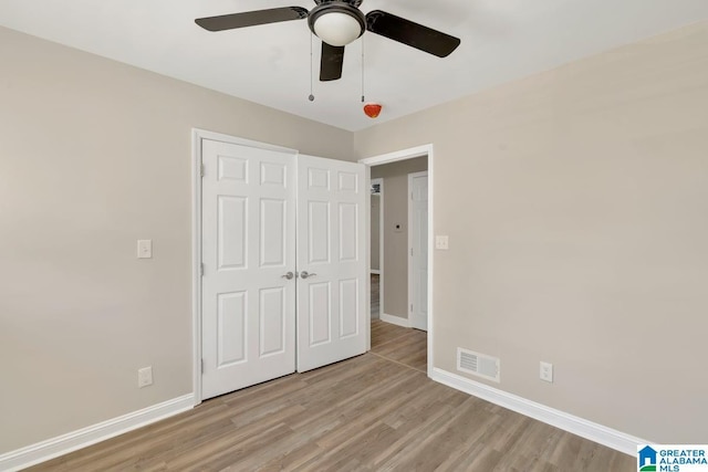 unfurnished bedroom with light wood-type flooring, visible vents, ceiling fan, and baseboards