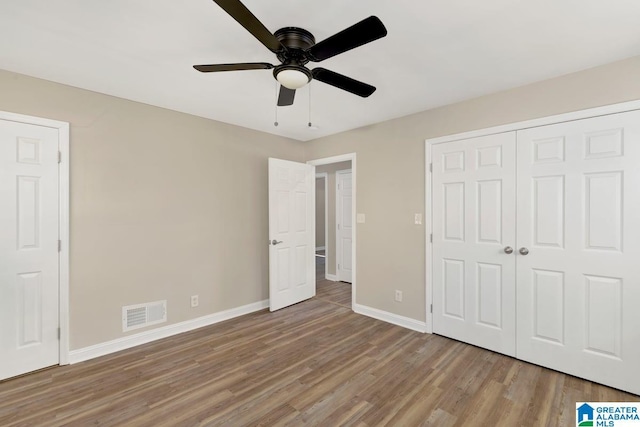 unfurnished bedroom featuring a closet, visible vents, ceiling fan, light wood-type flooring, and baseboards