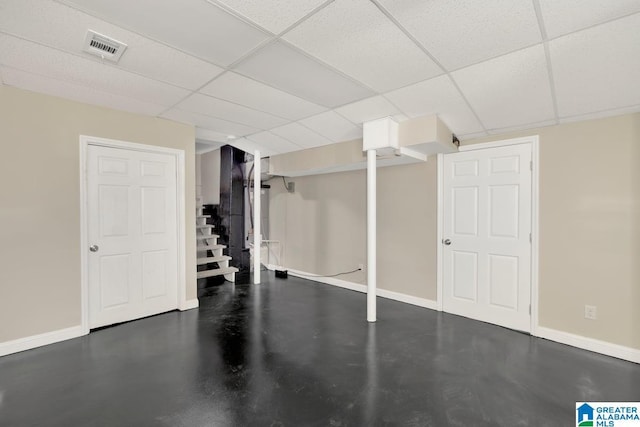 finished basement featuring a paneled ceiling, visible vents, baseboards, and stairs