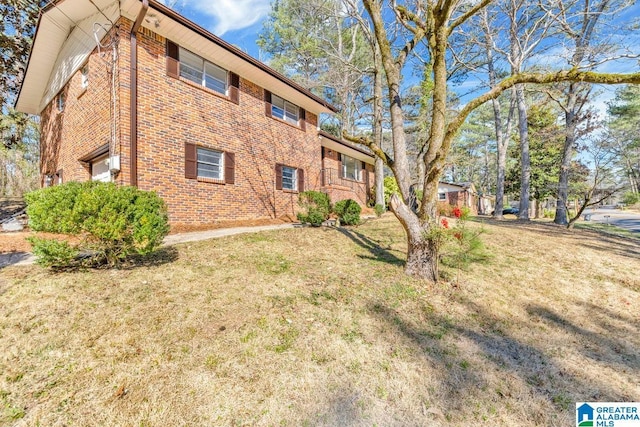 view of property exterior with a lawn and brick siding