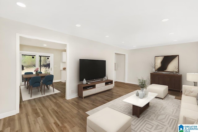 living room with recessed lighting, baseboards, and wood finished floors