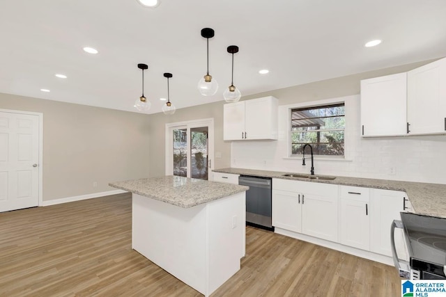 kitchen featuring pendant lighting, appliances with stainless steel finishes, white cabinets, a sink, and a kitchen island