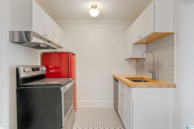 kitchen featuring sink, butcher block countertops, tasteful backsplash, appliances with stainless steel finishes, and white cabinets