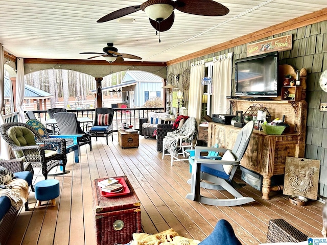 deck featuring a bar, outdoor lounge area, and ceiling fan