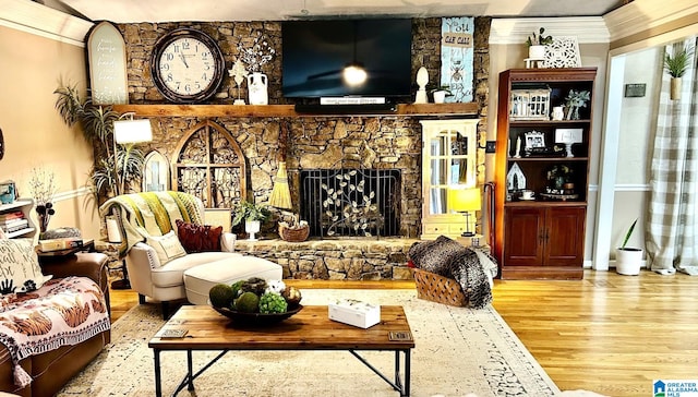 living room featuring crown molding, light wood-type flooring, and a fireplace