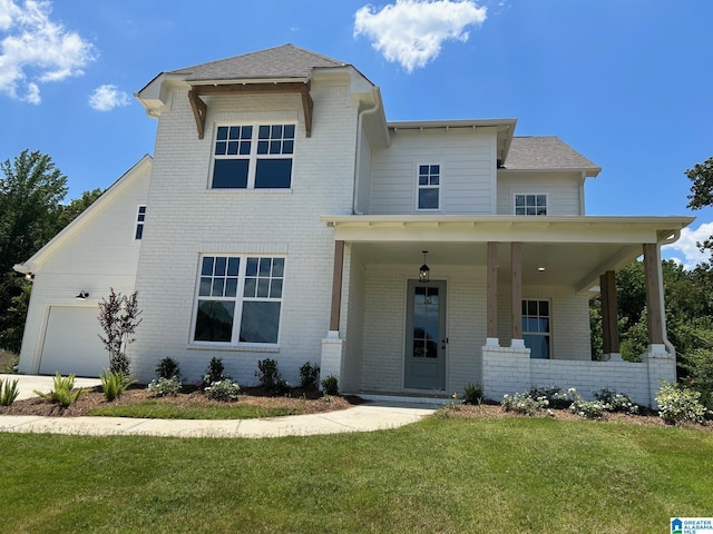 view of front facade with a garage, a front lawn, and a porch