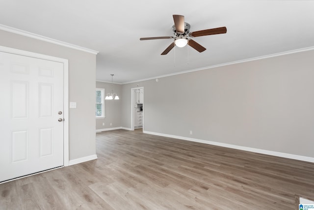 interior space with ornamental molding, ceiling fan with notable chandelier, and light wood-type flooring