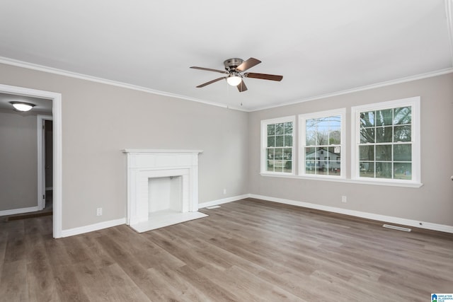 unfurnished living room with hardwood / wood-style flooring, crown molding, ceiling fan, and a fireplace