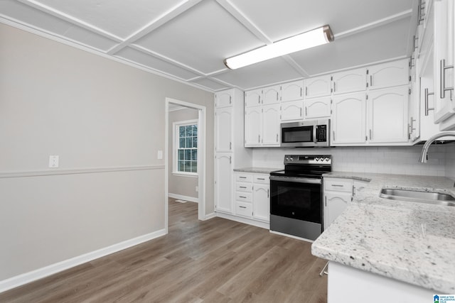 kitchen with stainless steel appliances, sink, decorative backsplash, and white cabinets