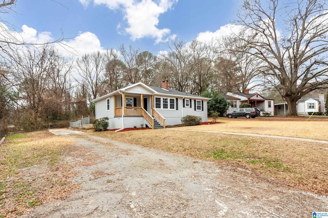 view of front of home featuring covered porch and a front lawn