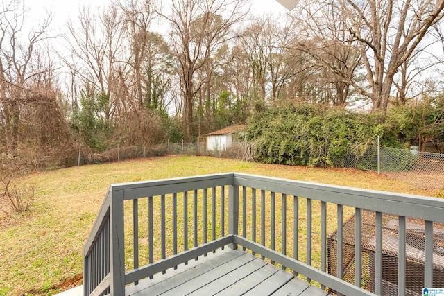 wooden deck featuring a yard and a storage unit