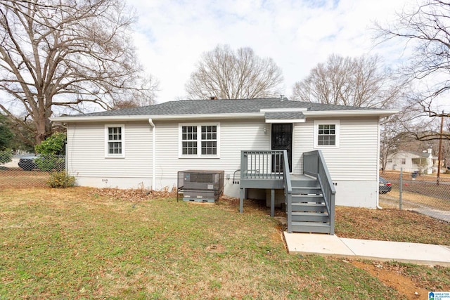 rear view of property featuring a yard and central air condition unit