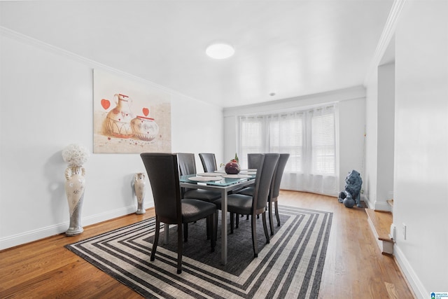 dining area with crown molding and wood-type flooring