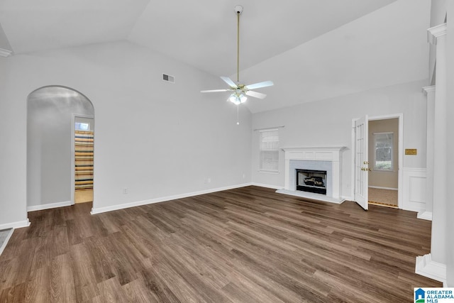 unfurnished living room with dark wood-type flooring, ceiling fan, and a wealth of natural light