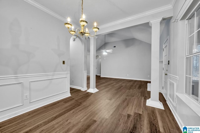 unfurnished dining area featuring dark hardwood / wood-style floors, lofted ceiling, ceiling fan with notable chandelier, ornamental molding, and decorative columns