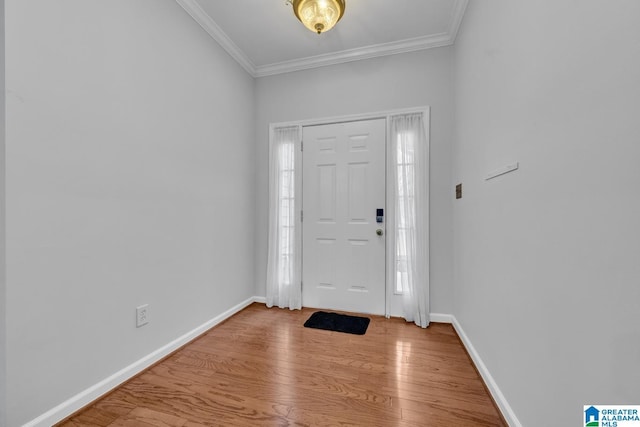 entrance foyer with ornamental molding and light hardwood / wood-style flooring