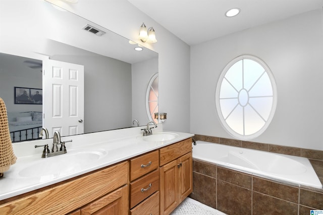 full bath with double vanity, visible vents, a sink, and a bath