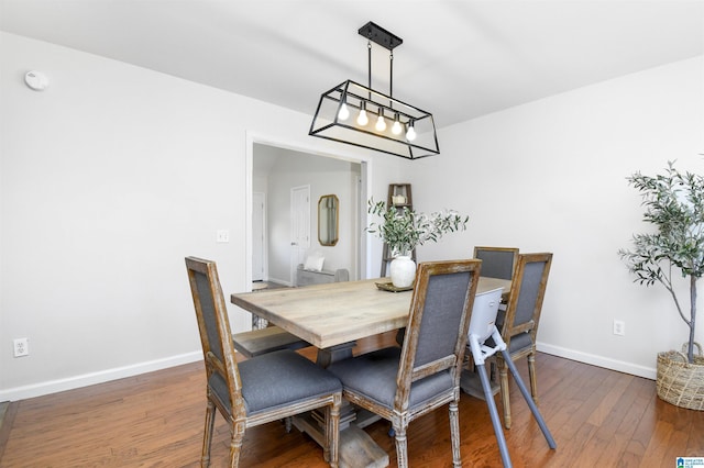 dining room with baseboards and dark wood-type flooring