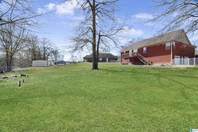 view of yard with fence, stairway, and a deck