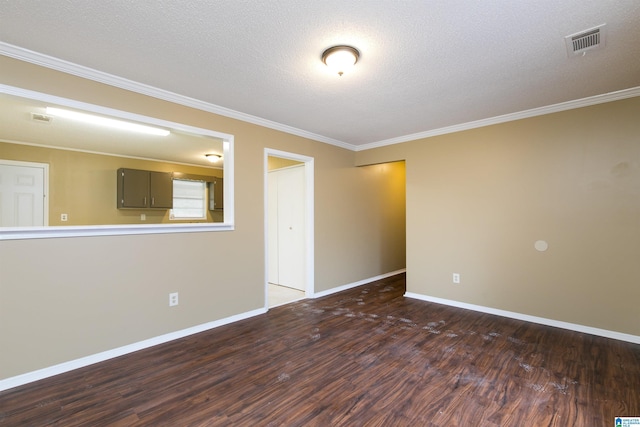 empty room featuring ornamental molding, dark wood-type flooring, and a textured ceiling