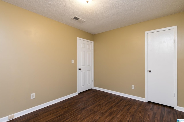 unfurnished room with dark hardwood / wood-style floors and a textured ceiling