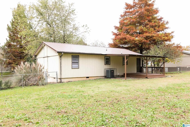 back of property with a wooden deck and a yard