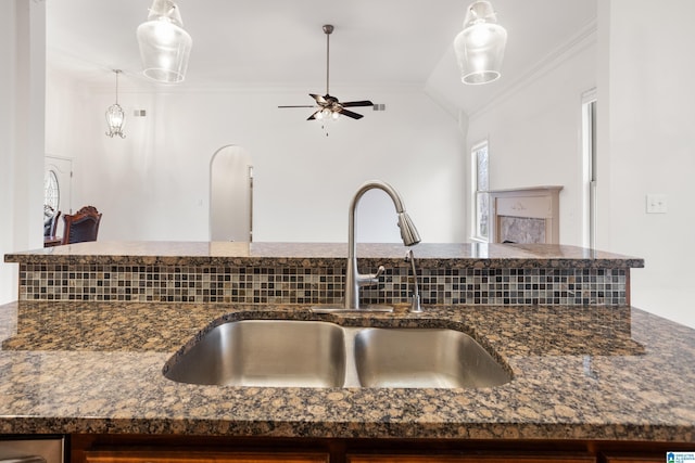 kitchen featuring sink, crown molding, ceiling fan, decorative light fixtures, and vaulted ceiling