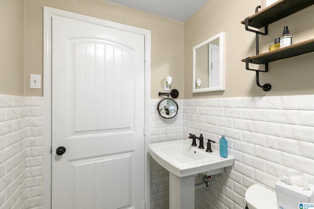 bathroom featuring tile walls and toilet