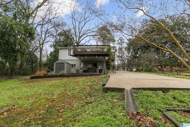 back of house featuring a wooden deck, a lawn, and a shed