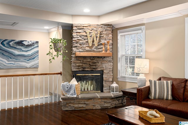 living room with a stone fireplace, wood-type flooring, and ornamental molding