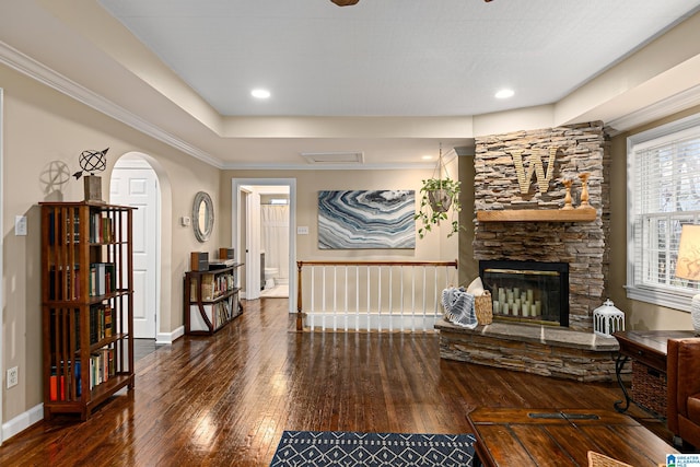 living room with dark hardwood / wood-style flooring and a stone fireplace