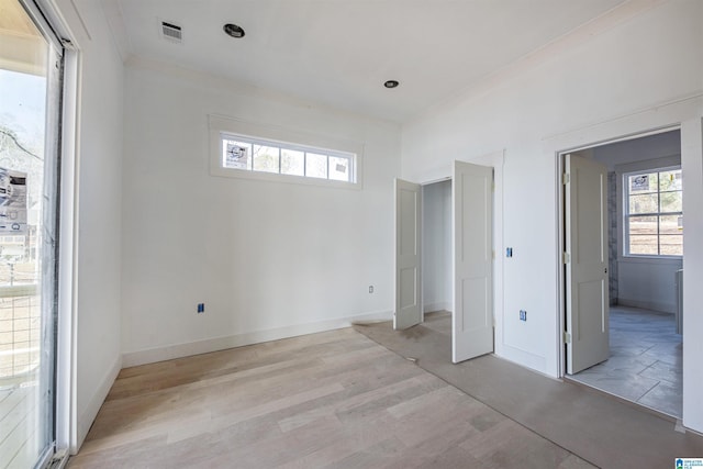 unfurnished bedroom featuring ornamental molding and light hardwood / wood-style floors