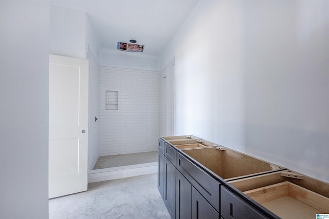 bathroom featuring tiled shower and concrete floors