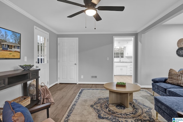 living room with ornamental molding, hardwood / wood-style floors, and ceiling fan