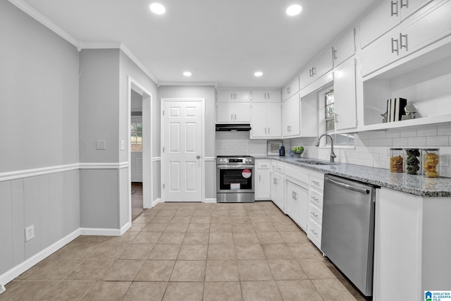 kitchen featuring appliances with stainless steel finishes, stone countertops, white cabinetry, sink, and a healthy amount of sunlight