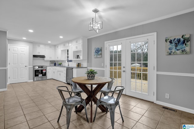 tiled dining area with ornamental molding, sink, an inviting chandelier, and french doors