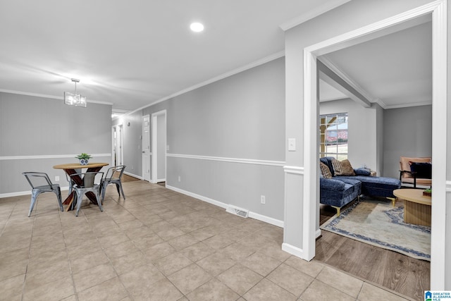 dining area featuring crown molding, light tile patterned flooring, and an inviting chandelier