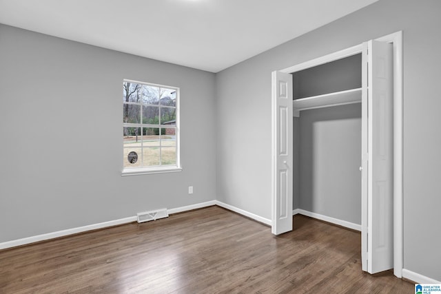 unfurnished bedroom with dark hardwood / wood-style flooring