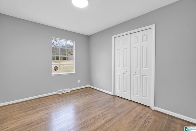 unfurnished bedroom with wood-type flooring and a closet