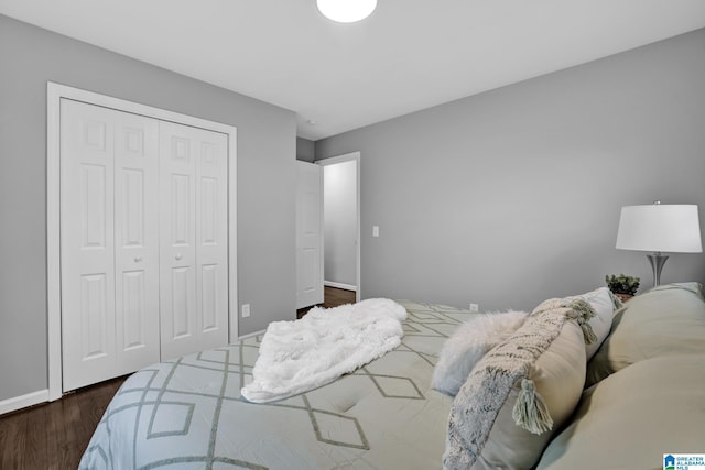 bedroom with dark hardwood / wood-style flooring and a closet