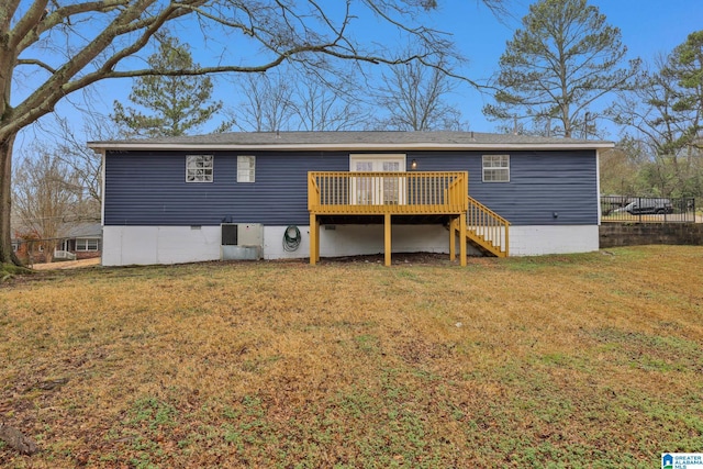 rear view of house featuring a deck and a lawn