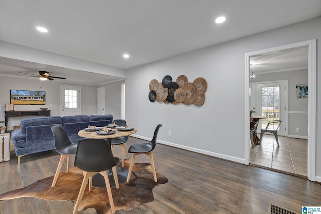 dining space featuring crown molding, a healthy amount of sunlight, and dark hardwood / wood-style floors