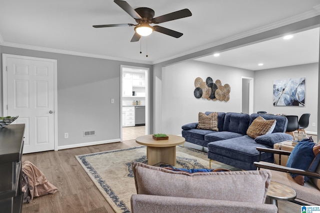 living room with crown molding, light hardwood / wood-style flooring, and ceiling fan