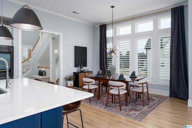 dining space featuring stairs, light wood-style floors, visible vents, and crown molding