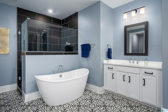 full bathroom featuring tile patterned flooring, vanity, baseboards, a freestanding bath, and a shower stall