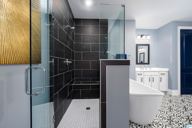 bathroom with a stall shower, tile patterned flooring, a freestanding bath, and vanity